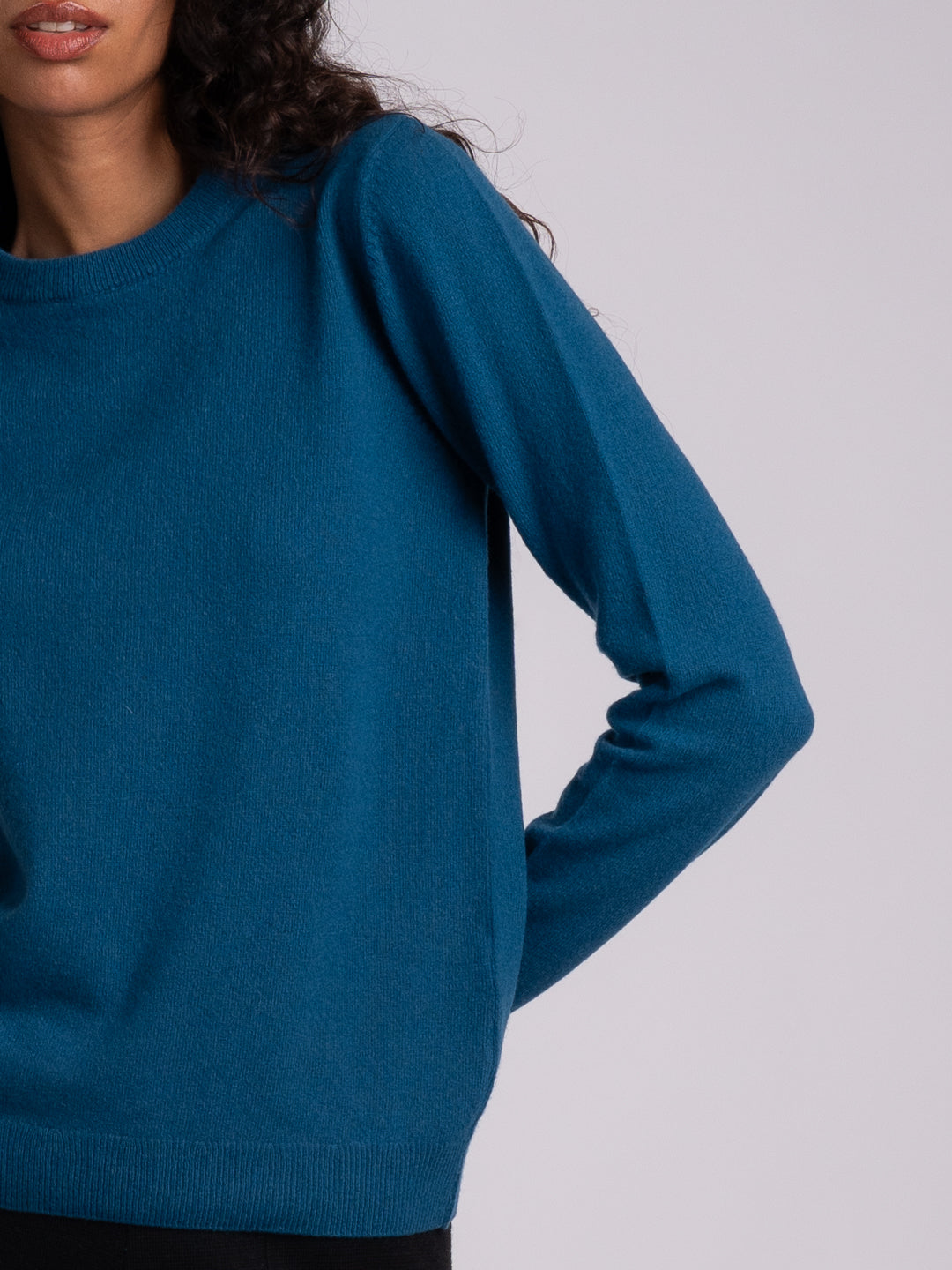 Detalhe da camisola de malha em Lambswool azul-petróleo | Achega