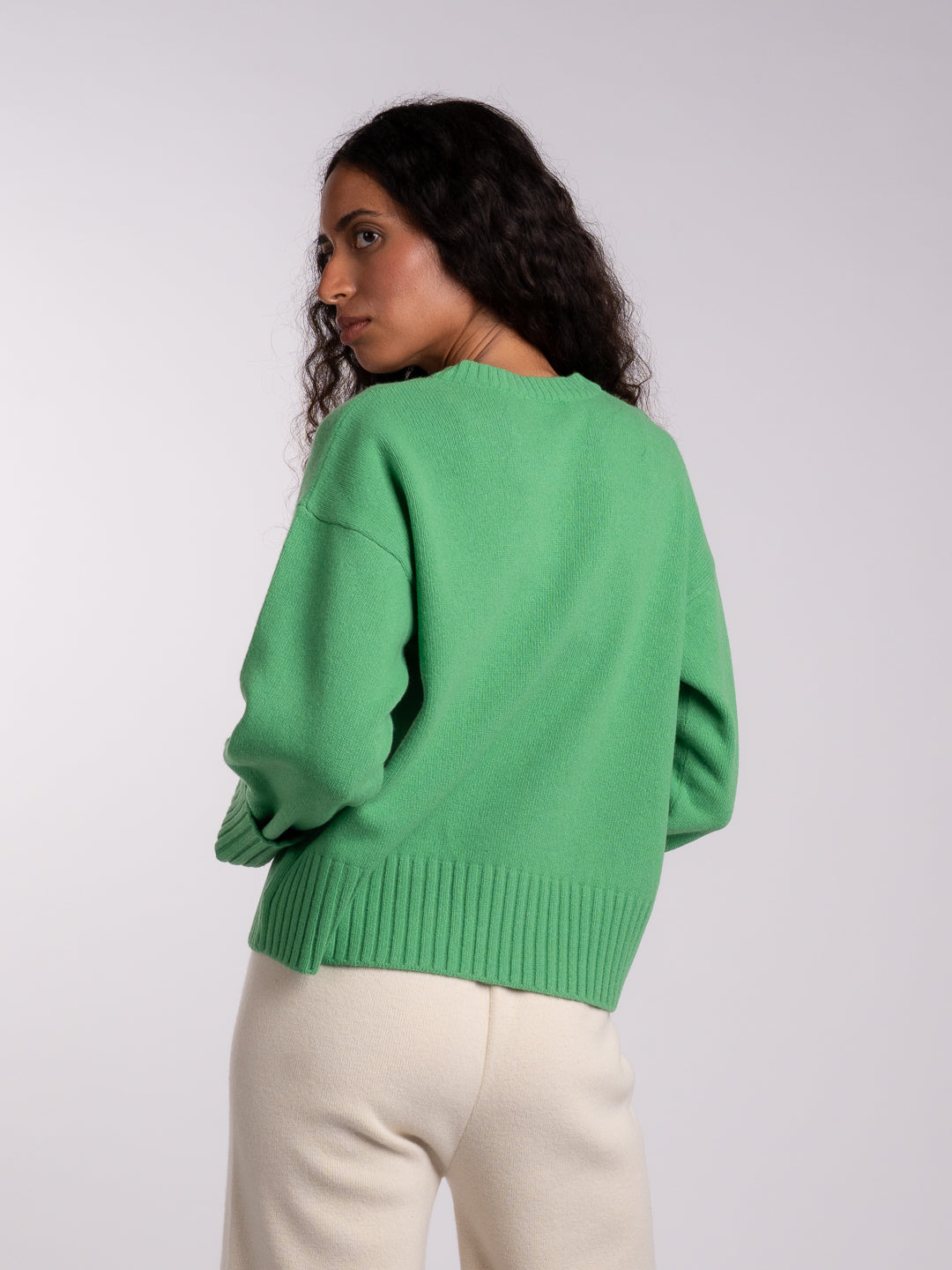 Detalhe dos punhos virados do camisolão em Lambswool verde Java | Achega
