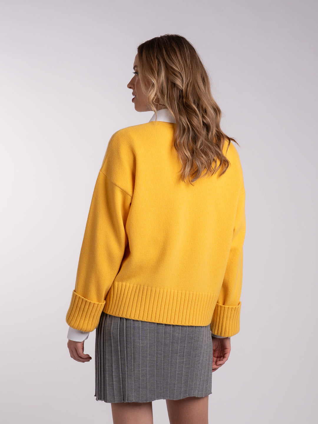Detalhe dos punhos virados do camisolão em Lambswool amarelo | Achega